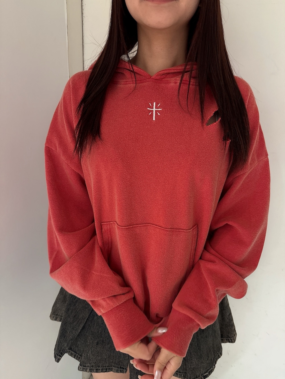 レッド系のパーカー、その他のデニムスカート、ブラック系のブーツを着用したレディースの秋コーディネートの7枚目の写真