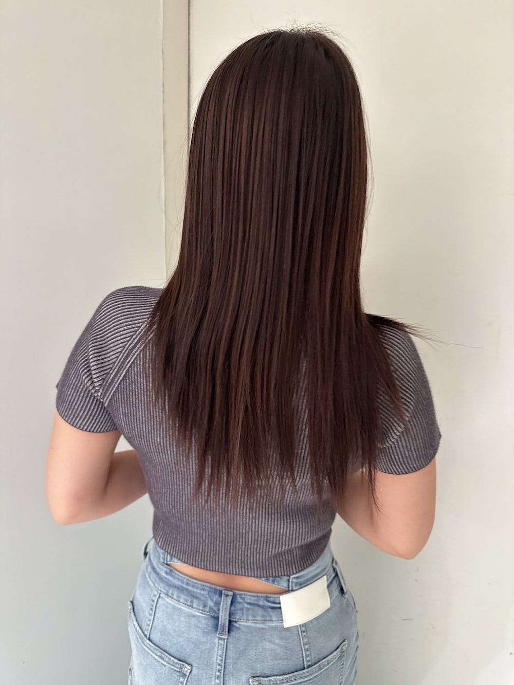 ホワイト系のニット/セーター、ブルー系のデニムスカート、ホワイト系のサンダルを着用したレディースの夏コーディネートの6枚目の写真