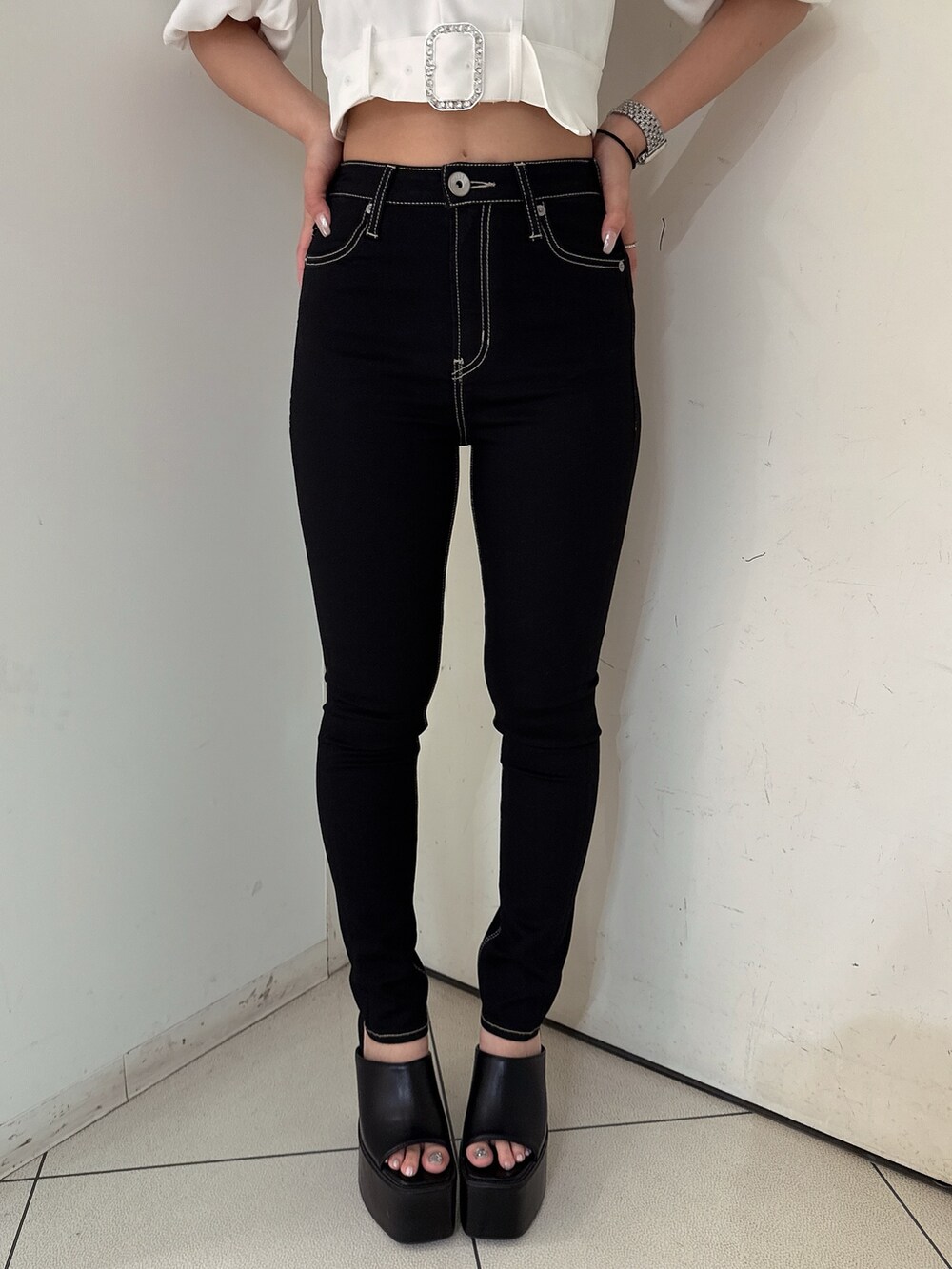 ブラック系のデニムパンツ、ブラック系のサンダル、ホワイト系のシャツ/ブラウスを着用したレディースの夏コーディネートの7枚目の写真