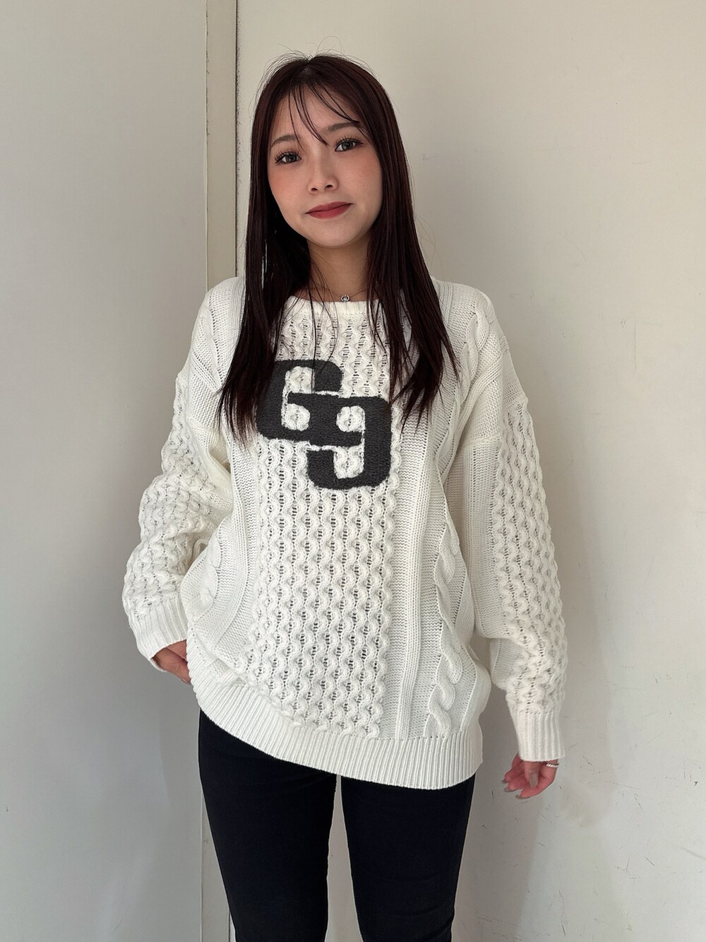 ホワイト系のニット/セーター、ブラック系のデニムパンツ、ブラック系のブーツを着用したレディースの秋コーディネートの4枚目の写真