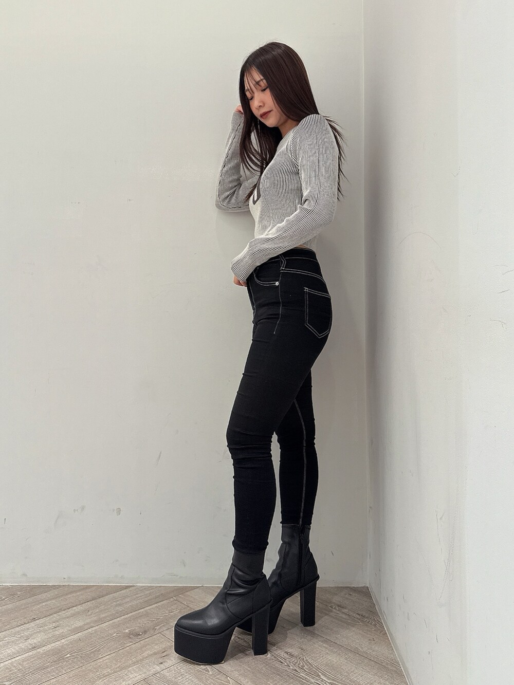 ブラック系のニット/セーター、ブラック系のデニムパンツ、ブラック系のブーツを着用したレディースの夏コーディネートの2枚目の写真