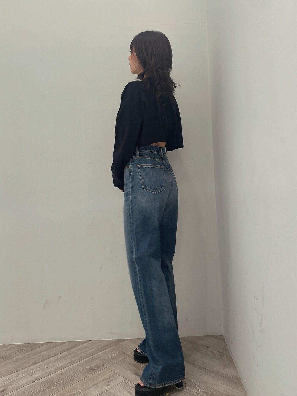 ブラック系のTシャツ/カットソー、ブルー系のデニムパンツ、ブラック系のブーツを着用したレディースの春コーディネートの2枚目の写真