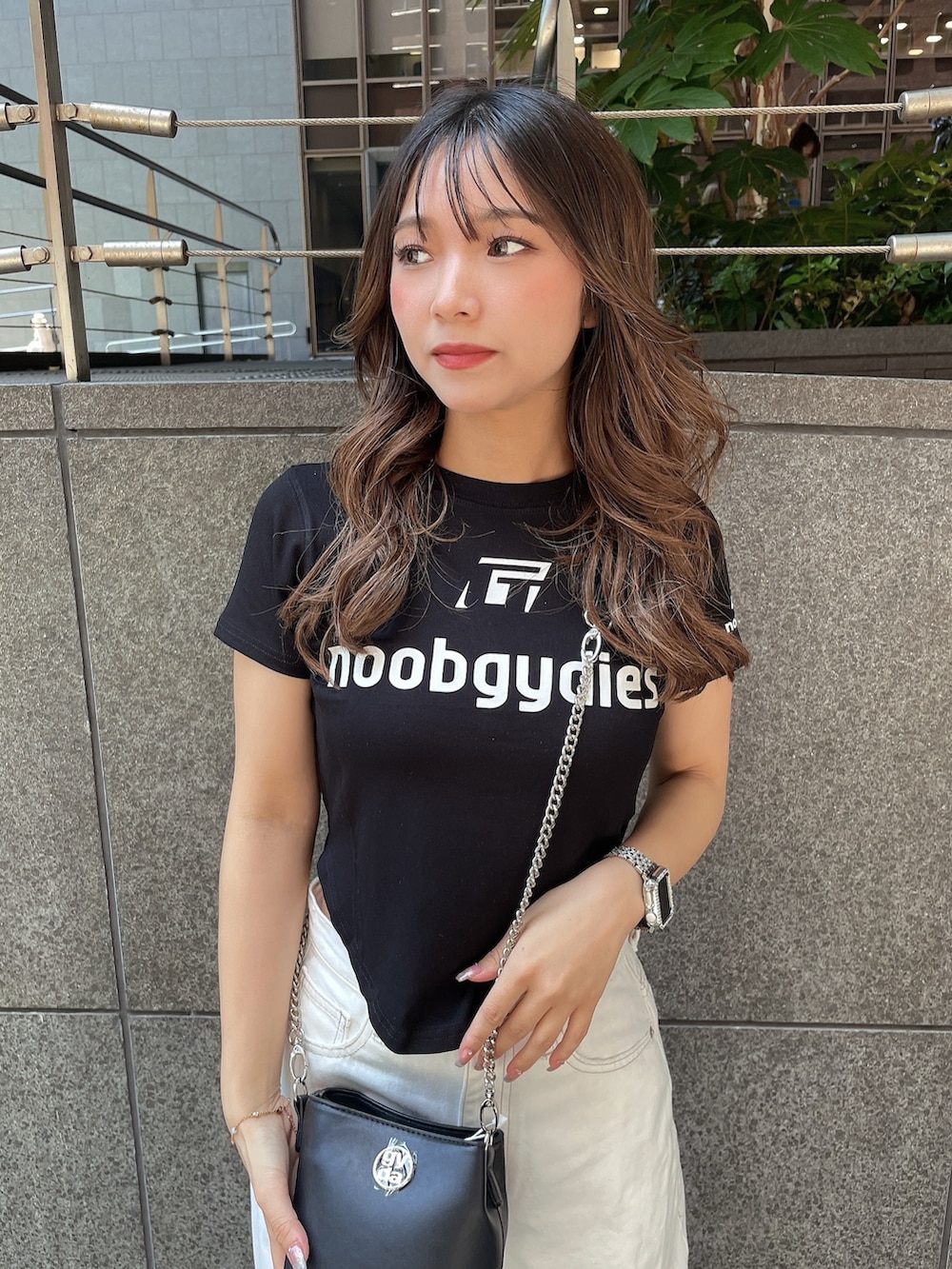 ブラック系のTシャツ/カットソー、ブラック系のショルダーバッグ、ブラック系のサンダルを着用したレディースの夏コーディネートの4枚目の写真