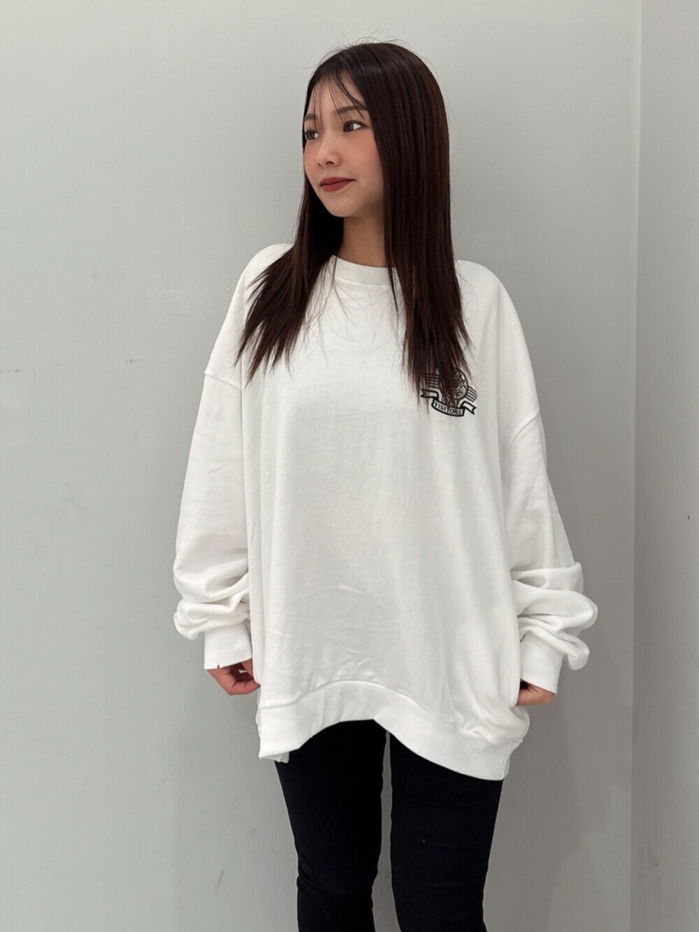 ブラック系のデニムパンツ、ホワイト系のスウェット、ブラック系のブーツを着用したレディースの夏コーディネートの4枚目の写真