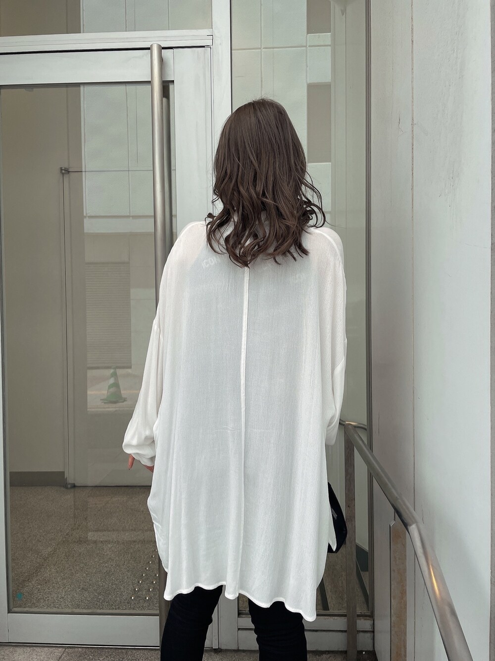 ホワイト系のサンダル、ブラック系のデニムパンツ、ブラック系のハンドバッグを着用したレディースの春コーディネートの4枚目の写真