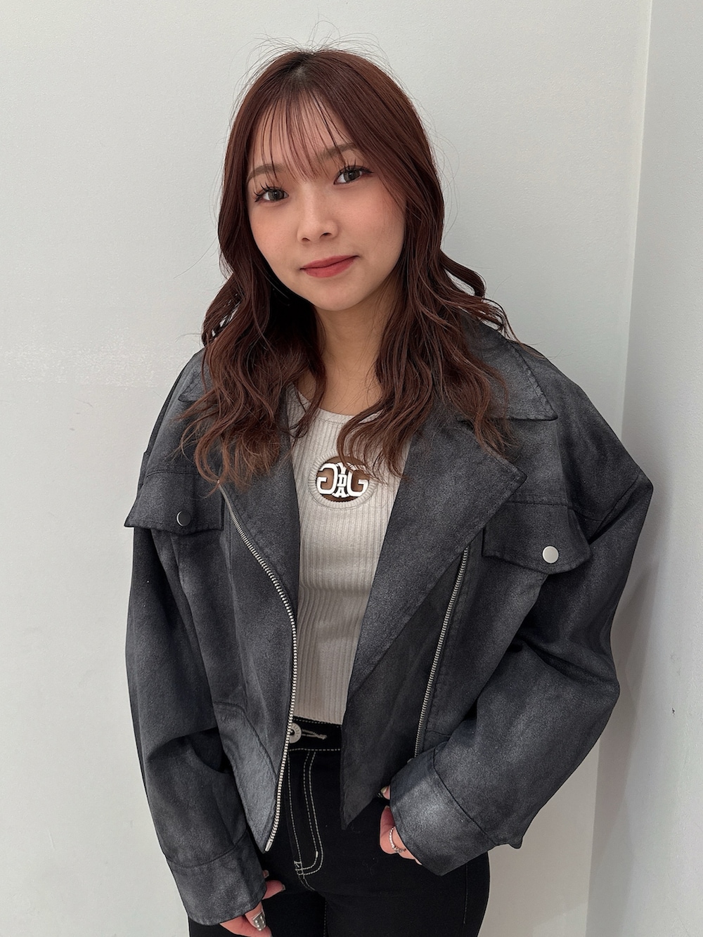 ブラック系のテーラードジャケット、グレー系のニット/セーター、ブラック系のデニムパンツを着用したレディースの冬コーディネートの4枚目の写真