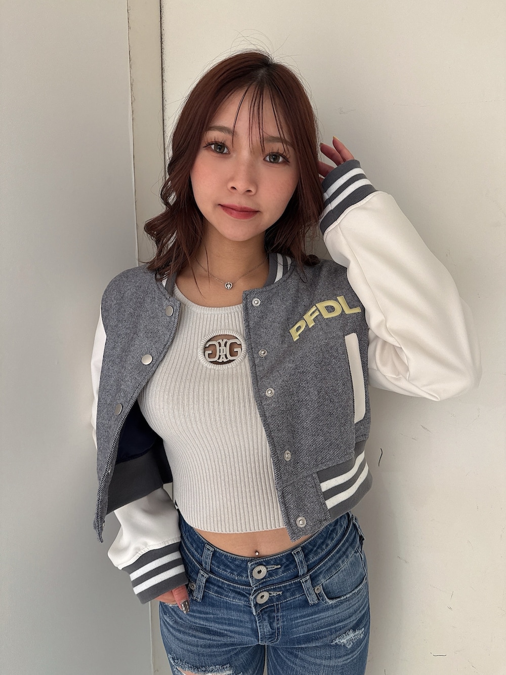 グレー系のニット/セーター、ブルー系のデニムパンツ、ホワイト系のパンプスを着用したレディースの冬コーディネートの4枚目の写真