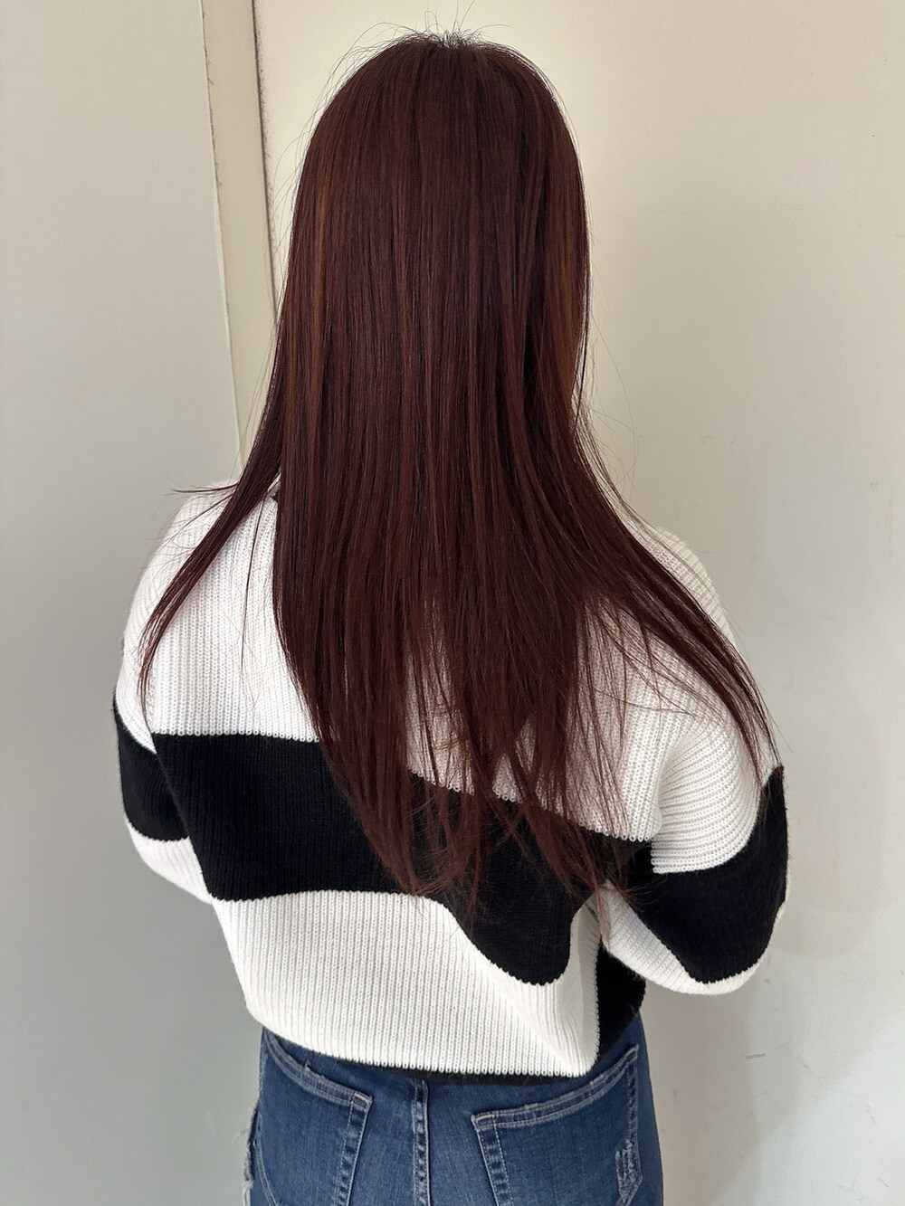 ブルー系のデニムパンツ、ブラック系のブーツ、ブラック系のニット/セーターを着用したレディースの秋コーディネートの6枚目の写真