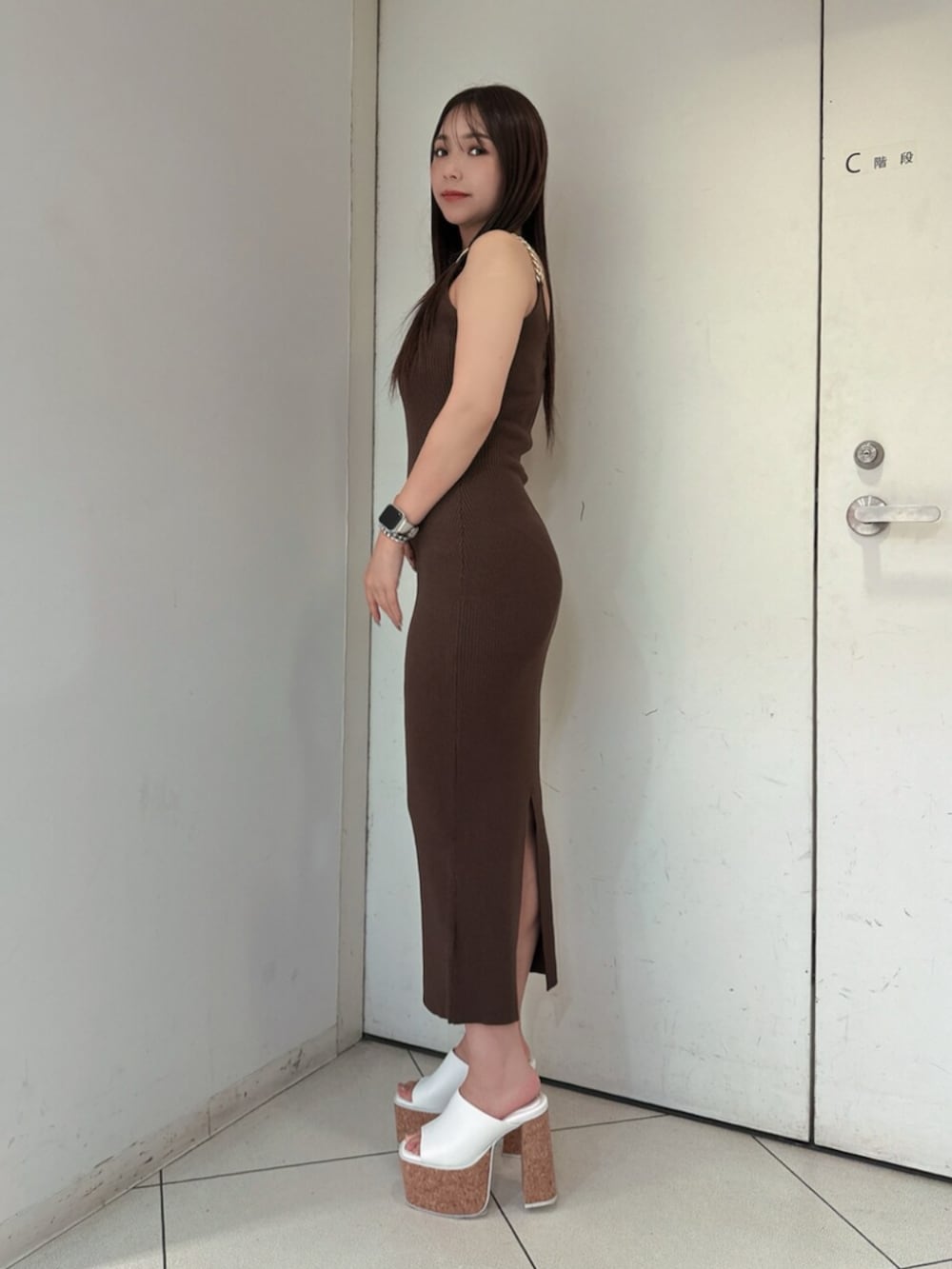 ホワイト系のサンダル、ブラウン系のワンピースを着用したレディースの夏コーディネートの2枚目の写真