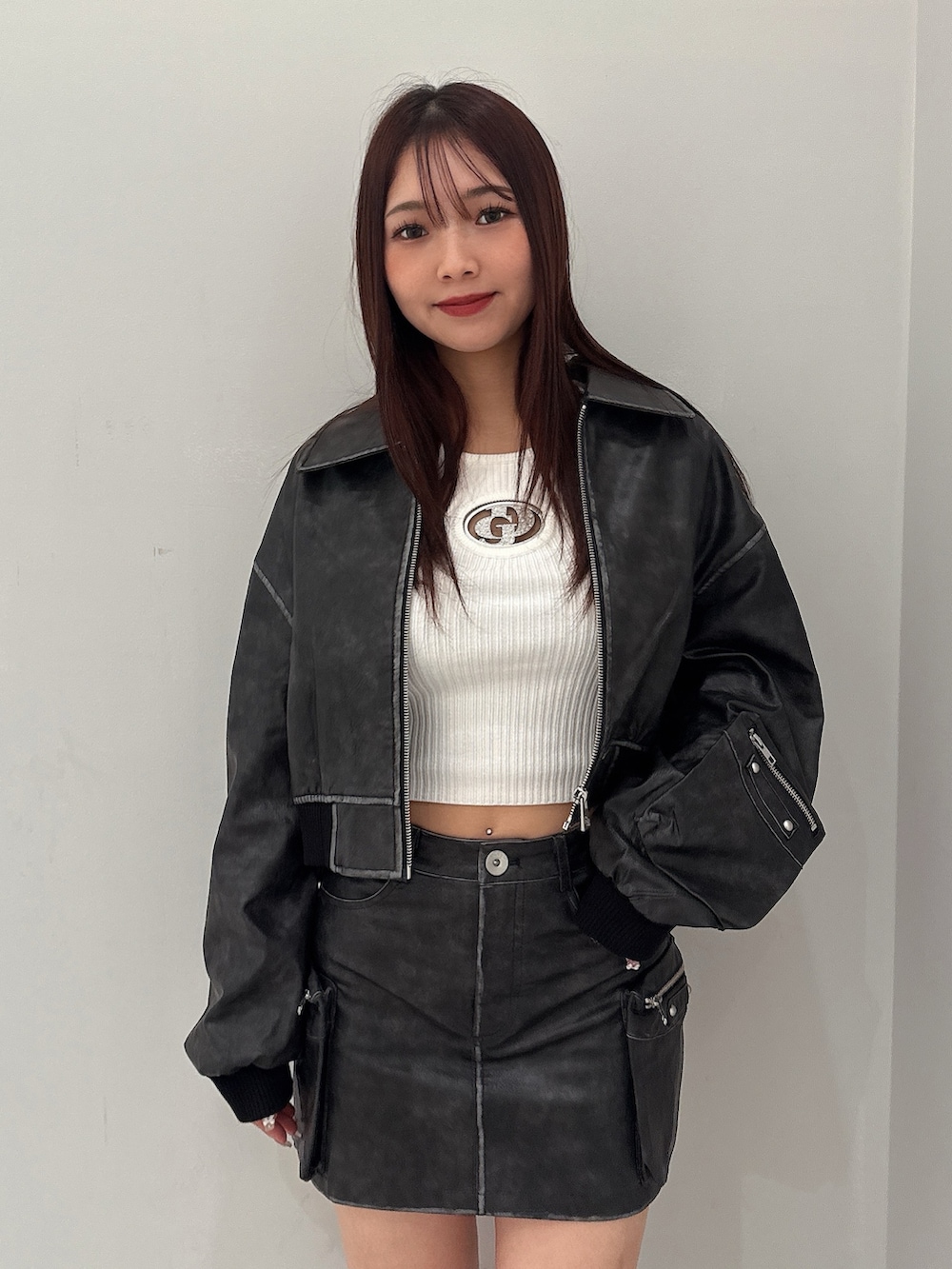 ブラック系のブーツ、ホワイト系のニット/セーター、ブラック系のスカートを着用したレディースの秋コーディネートの4枚目の写真