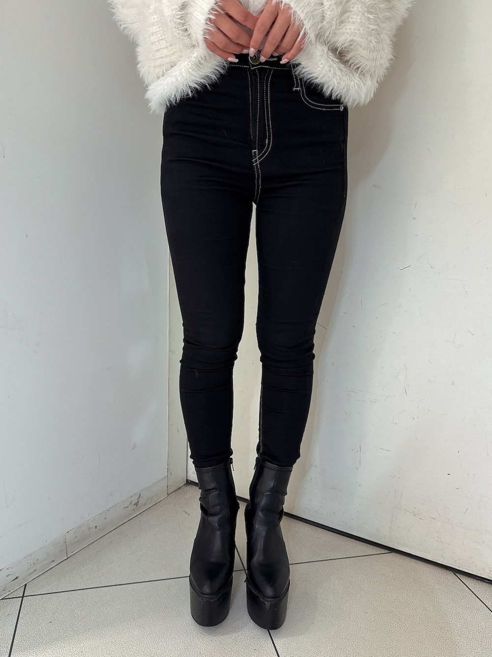 ブラック系のデニムパンツ、ブラック系のブーツ、ホワイト系のニット/セーターを着用したレディースの秋コーディネートの8枚目の写真