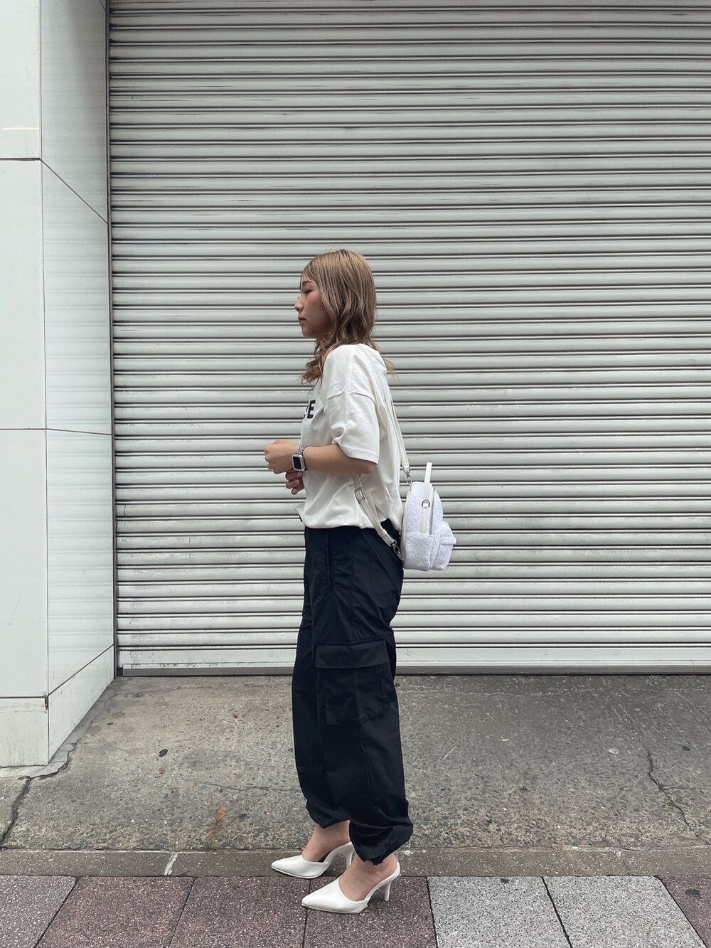 ホワイト系のバックパック/リュック、ホワイト系のTシャツ/カットソー、ブラック系のカーゴパンツを着用したレディースの夏コーディネートの4枚目の写真