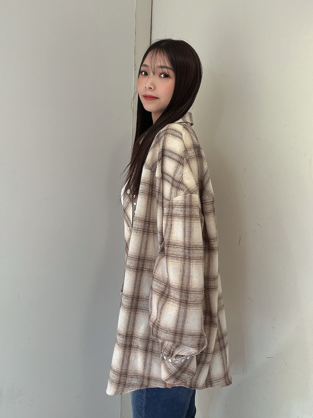 ベージュ系のシャツ/ブラウス、ブルー系のデニムパンツ、ブラック系のサンダルを着用したレディースの春コーディネートの5枚目の写真