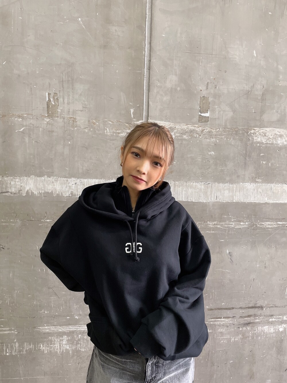 ブラック系のスウェット、ブラック系のデニムスカート、ブラウン系のブーツを着用したレディースの秋コーディネートの2枚目の写真