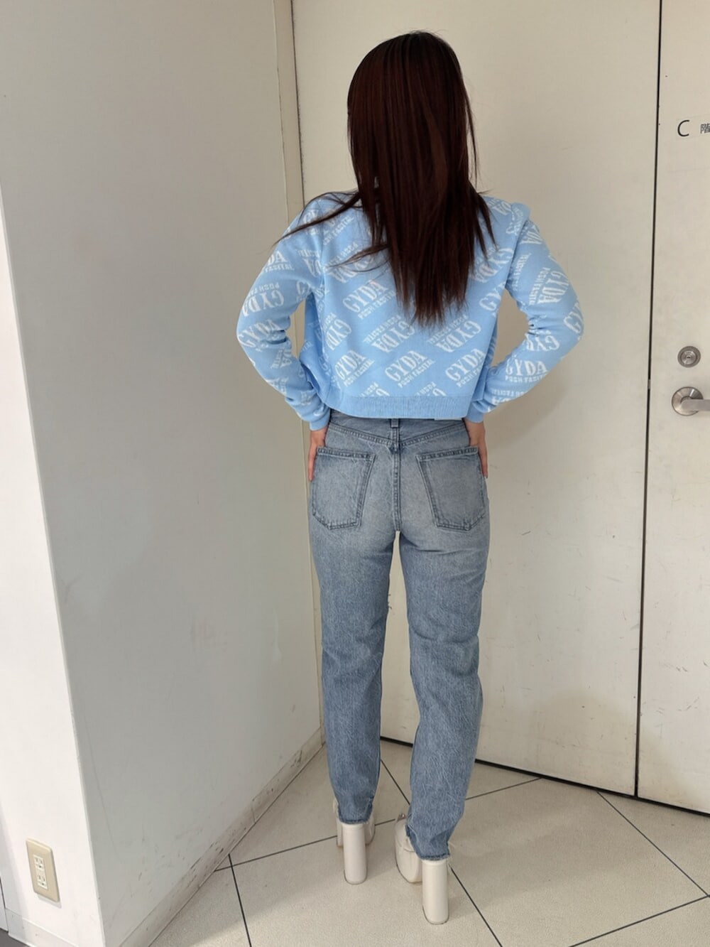 ブラック系のサンダル、ブルー系のデニムパンツ、ホワイト系のキャミソールを着用したレディースの夏コーディネートの3枚目の写真