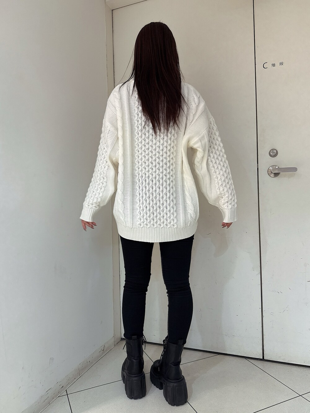 ホワイト系のニット/セーター、ブラック系のデニムパンツ、ブラック系のブーツを着用したレディースの秋コーディネートの3枚目の写真