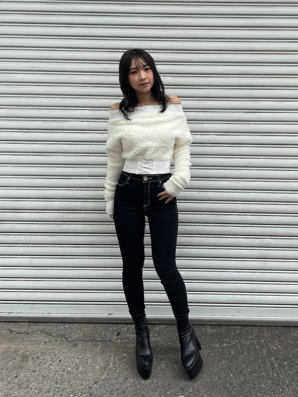 ブラック系のダウンジャケット/コート、ホワイト系のニット/セーター、ブラック系のデニムパンツを着用したレディースの冬コーディネートの5枚目の写真