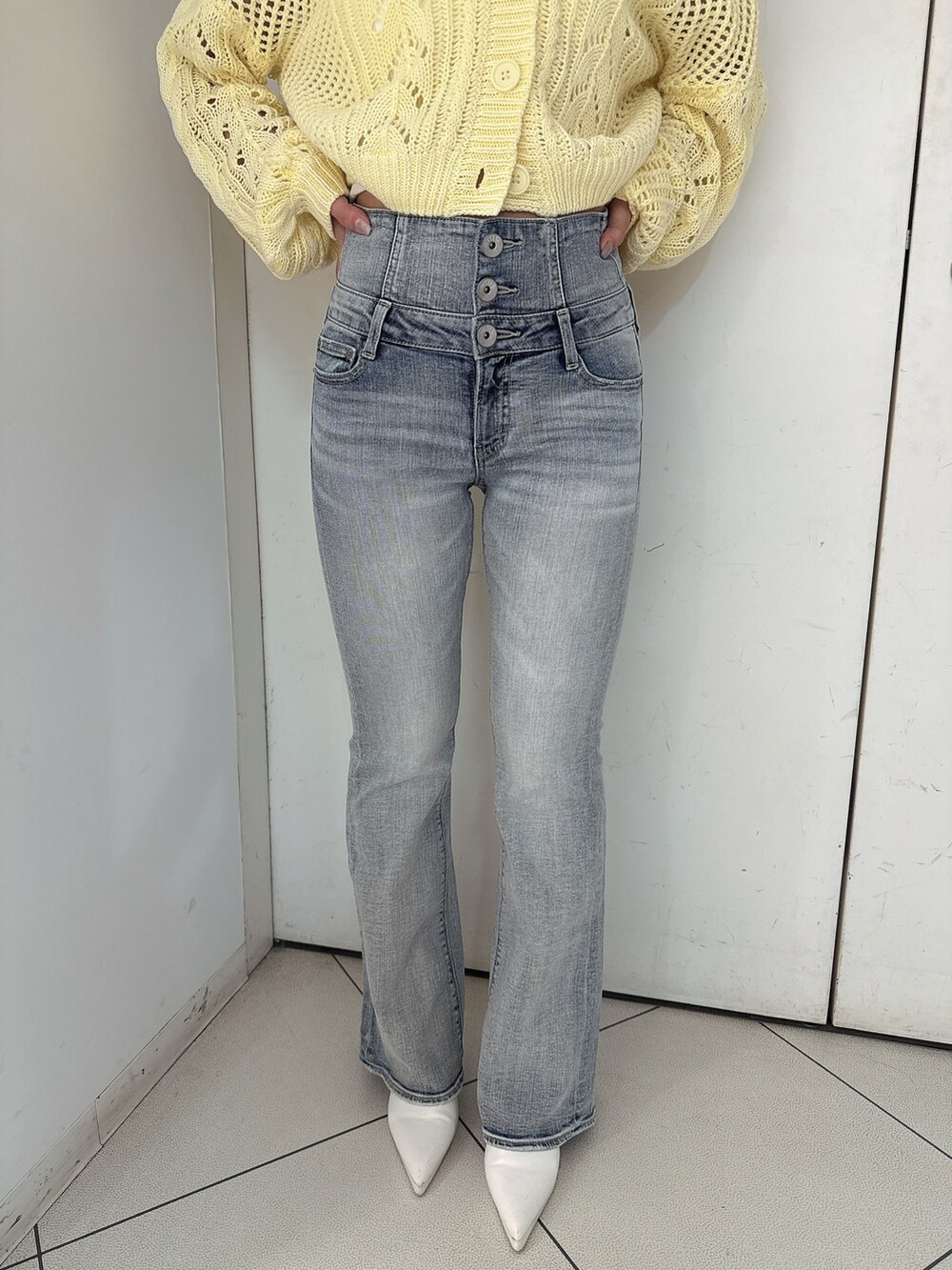 ホワイト系のパンプス、ブルー系のデニムパンツ、ホワイト系のキャミソールを着用したレディースの春コーディネートの9枚目の写真