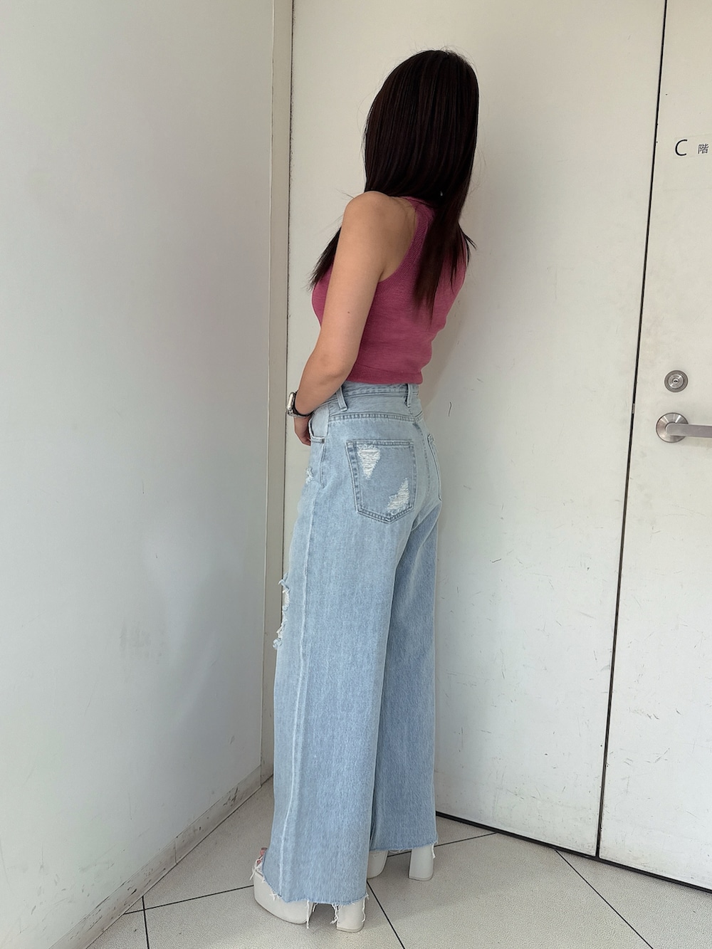 ブルー系のデニムパンツ、ホワイト系のサンダル、ピンク系のニット/セーターを着用したレディースの夏コーディネートの2枚目の写真