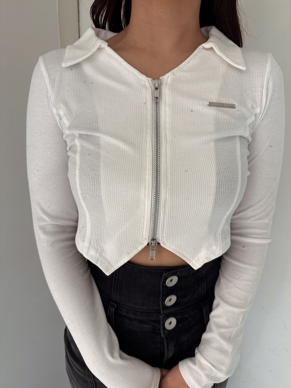 ブラック系のデニムスカート、ブラック系のTシャツ/カットソー、ホワイト系のパンプスを着用したレディースの秋コーディネートの7枚目の写真