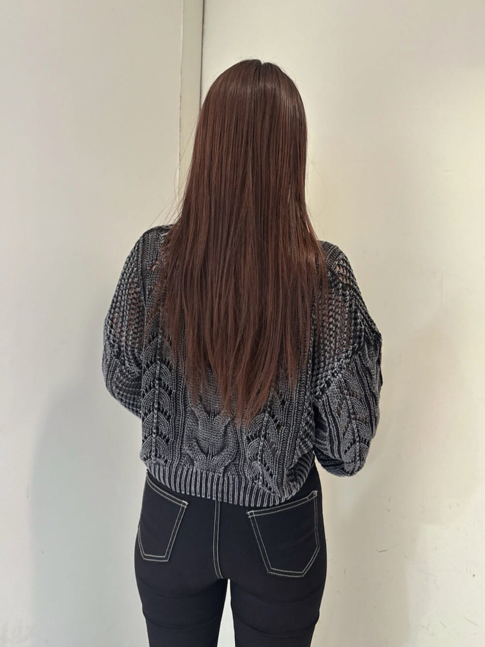 ブラック系のデニムパンツ、ブラック系のブーツ、ブラック系のニット/セーターを着用したレディースの夏コーディネートの6枚目の写真