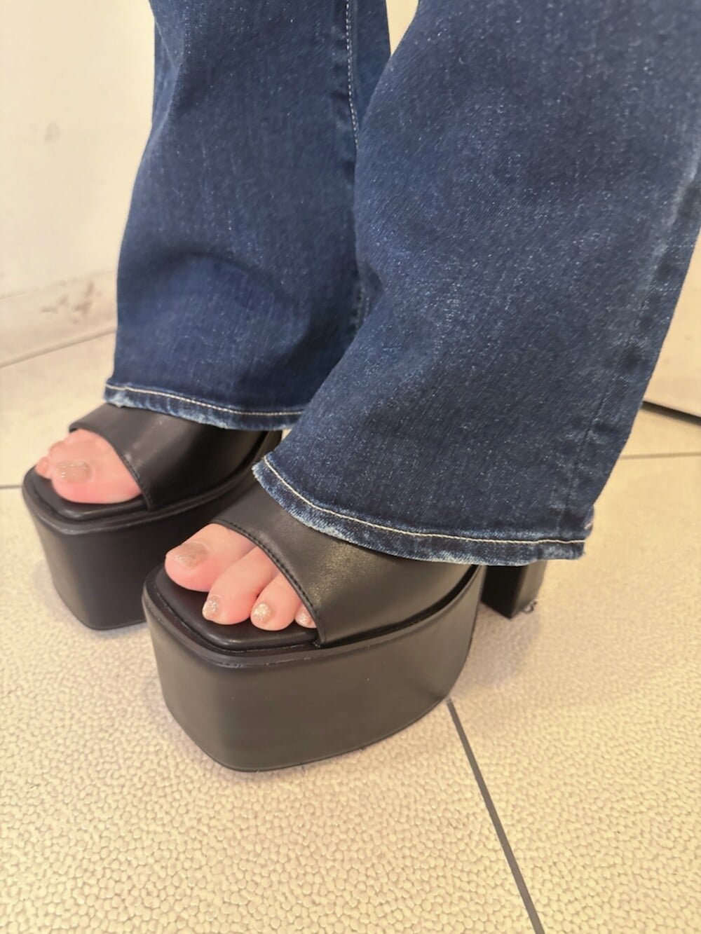 ブルー系のデニムパンツ、ブラック系のサンダル、グレー系のTシャツ/カットソーを着用したレディースの夏コーディネートの9枚目の写真