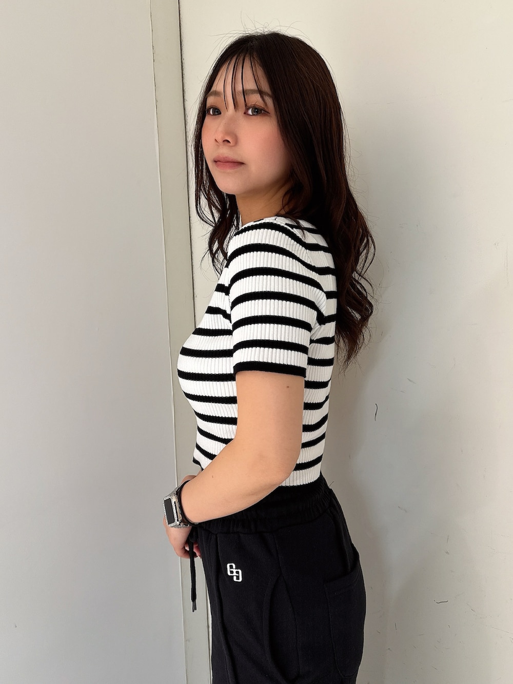 ブラック系のスウェットパンツ、ホワイト系のスニーカー、ブラック系のニット/セーターを着用したレディースの春コーディネートの5枚目の写真