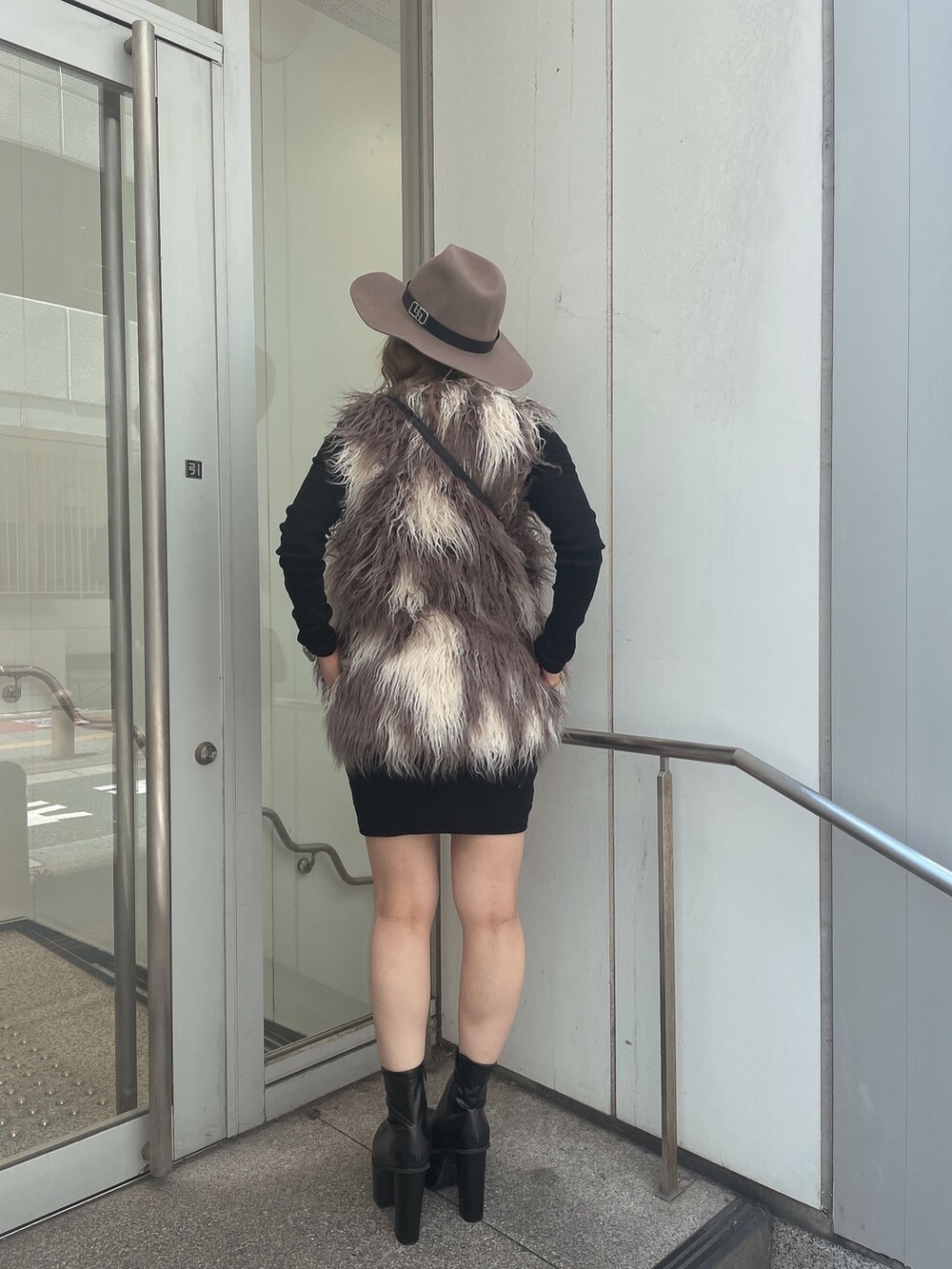 ブラック系のワンピース、その他のベスト、ブラック系のハンドバッグを着用したレディースの秋コーディネートの2枚目の写真