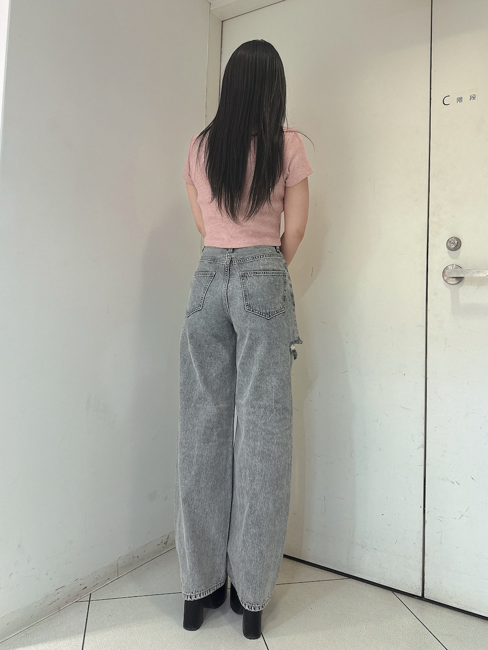 ブルー系のデニムパンツ、ピンク系のTシャツ/カットソー、ブラック系のサンダルを着用したレディースの春コーディネートの3枚目の写真