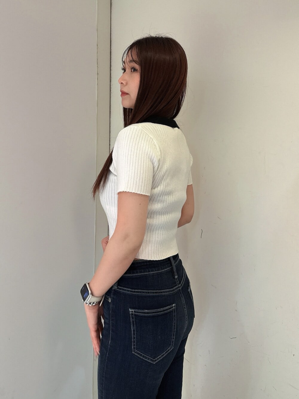 ブルー系のデニムパンツ、ブラック系のサンダル、ホワイト系のニット/セーターを着用したレディースの春コーディネートの5枚目の写真