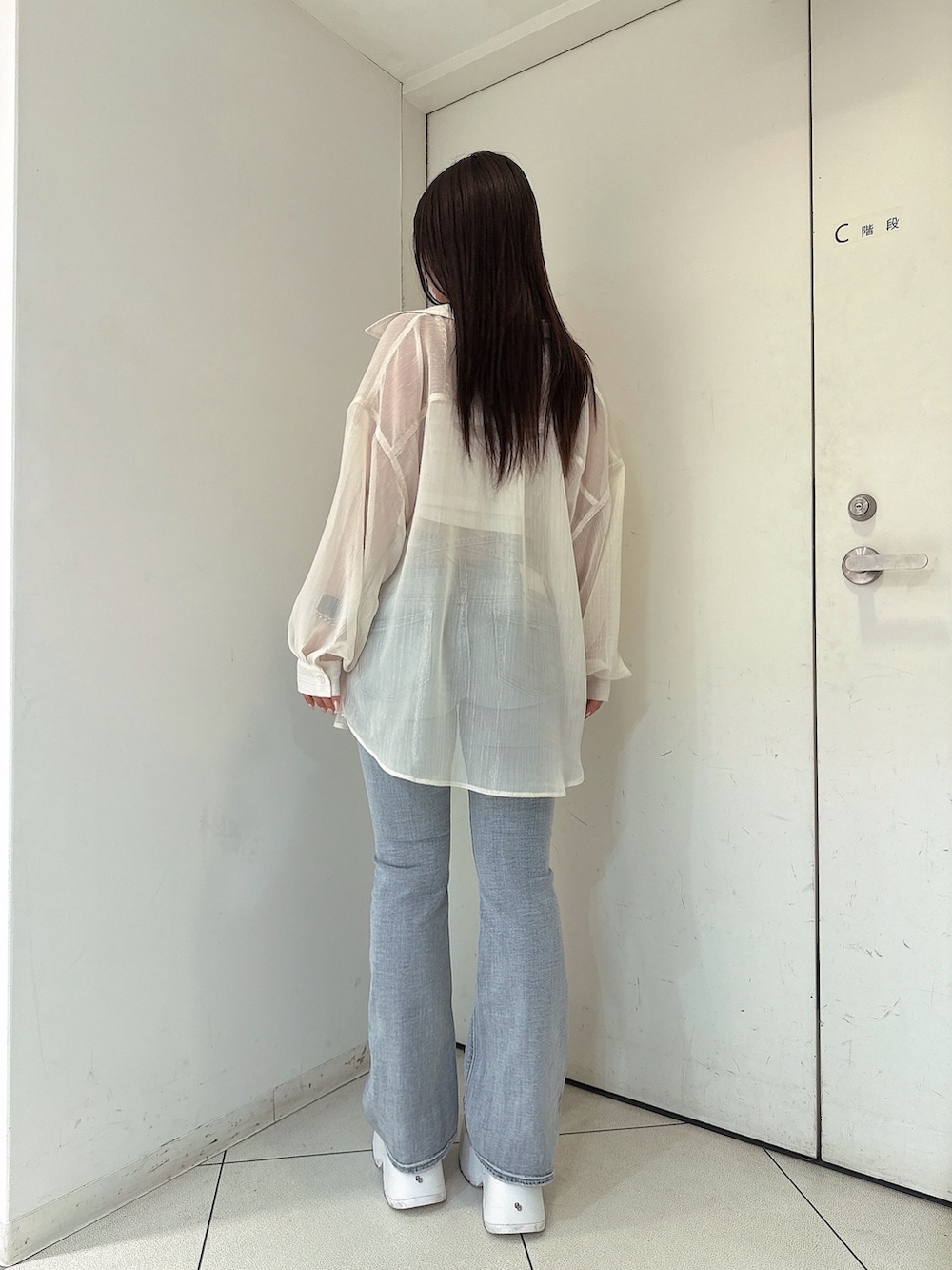 ブルー系のデニムパンツ、ホワイト系のチューブトップ、ホワイト系のシャツ/ブラウスを着用したレディースの春コーディネートの3枚目の写真