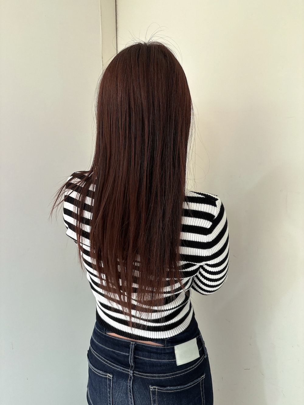 ブルー系のデニムパンツ、ブラック系のブーツ、その他のニット/セーターを着用したレディースの冬コーディネートの6枚目の写真