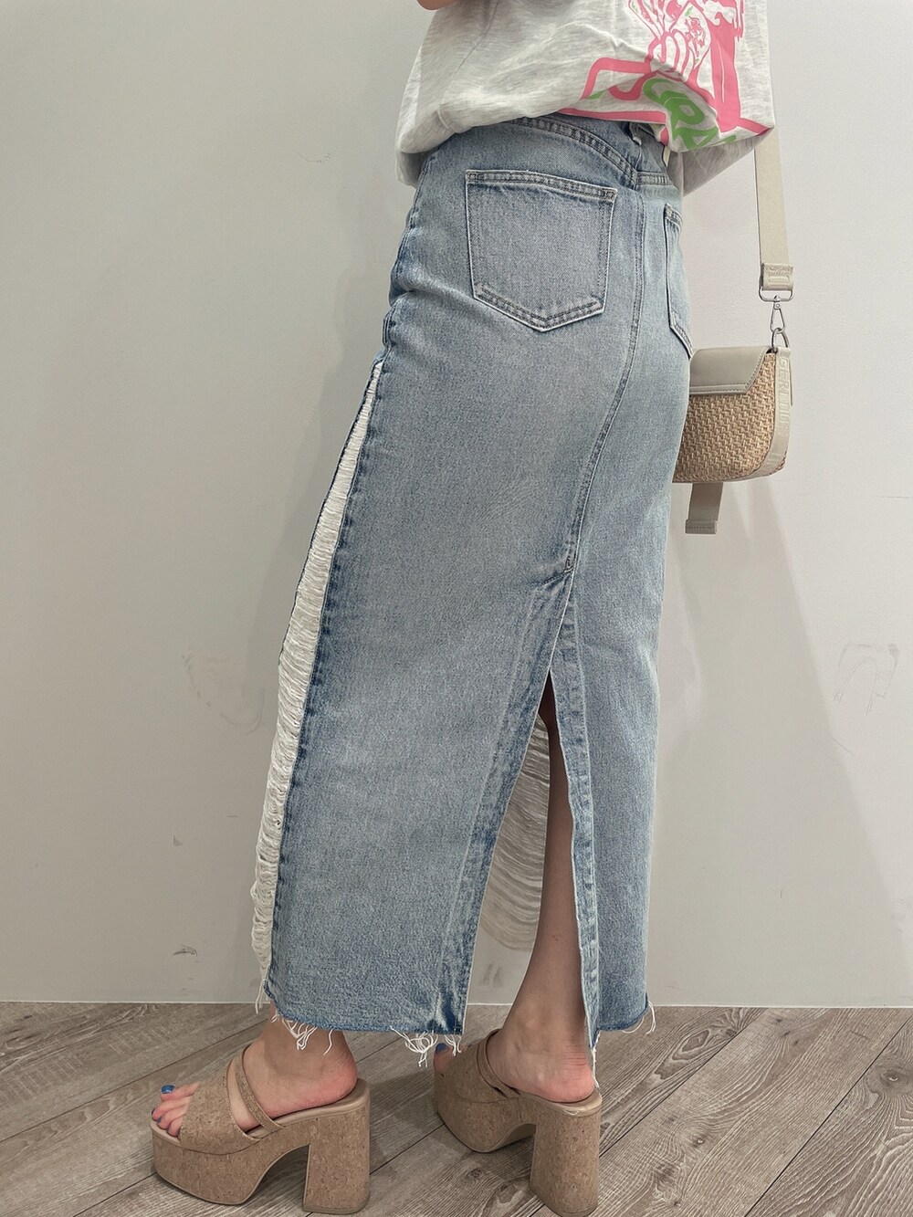 ホワイト系のTシャツ/カットソー、ブルー系のデニムスカート、ホワイト系のサンダルを着用したレディースの春コーディネートの9枚目の写真