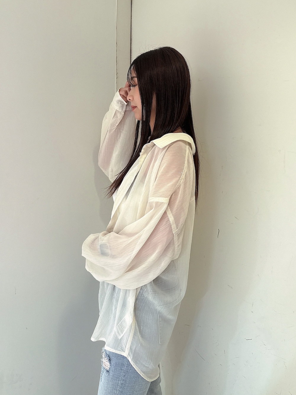 ブルー系のデニムパンツ、ホワイト系のチューブトップ、ホワイト系のシャツ/ブラウスを着用したレディースの春コーディネートの5枚目の写真
