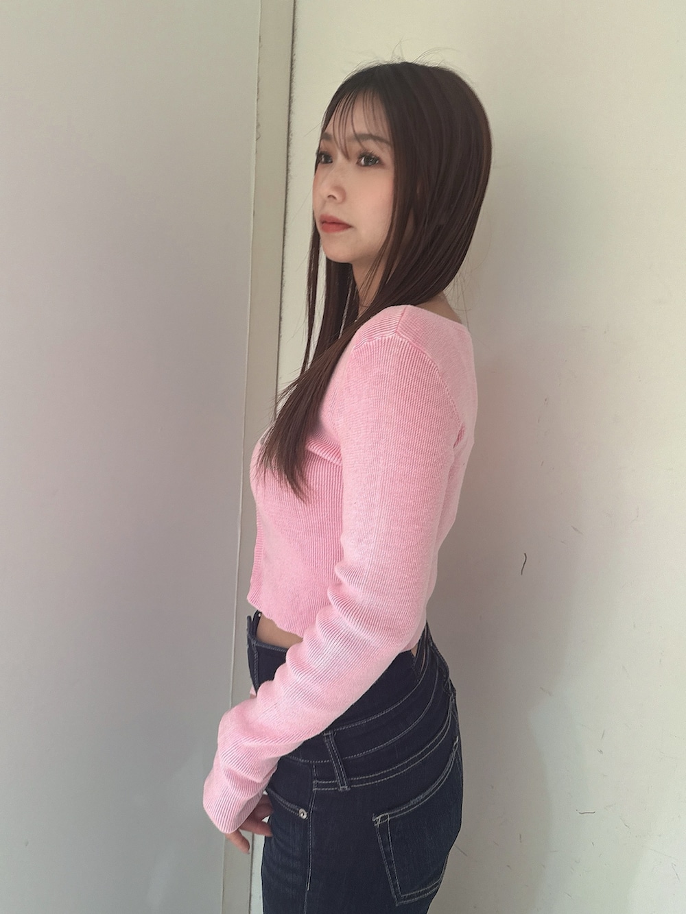 ブルー系のデニムパンツ、ブラック系のサンダル、ピンク系のニット/セーターを着用したレディースの春コーディネートの5枚目の写真