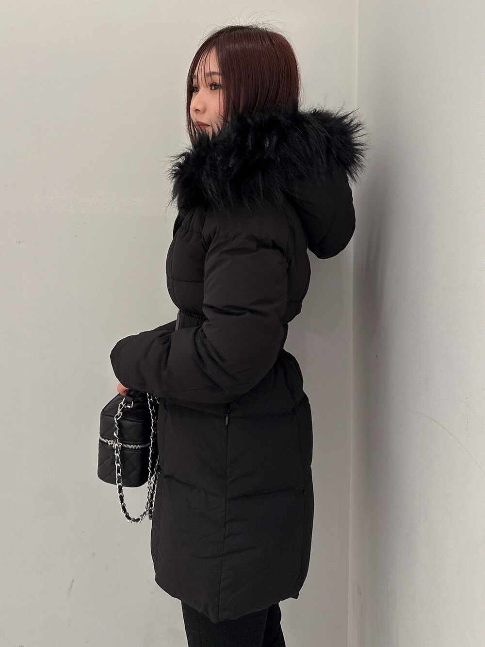 ブラック系のダウンジャケット/コート、ブラック系のデニムパンツ、ブラック系のブーツを着用したレディースの冬コーディネートの5枚目の写真