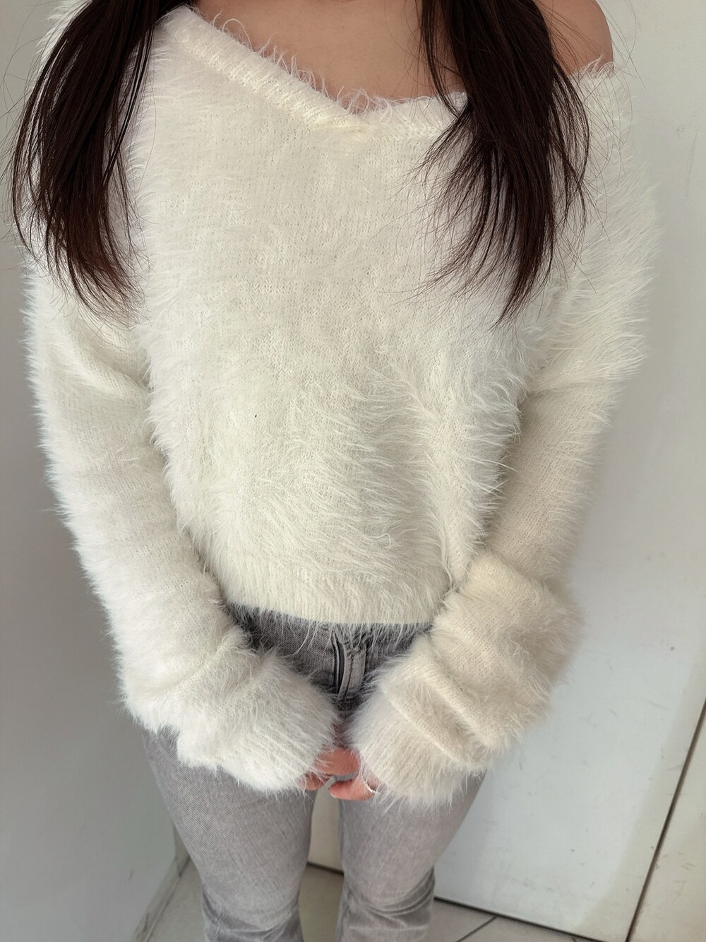 ホワイト系のニット/セーター、グレー系のデニムパンツ、ブラック系のブーツを着用したレディースの冬コーディネートの7枚目の写真