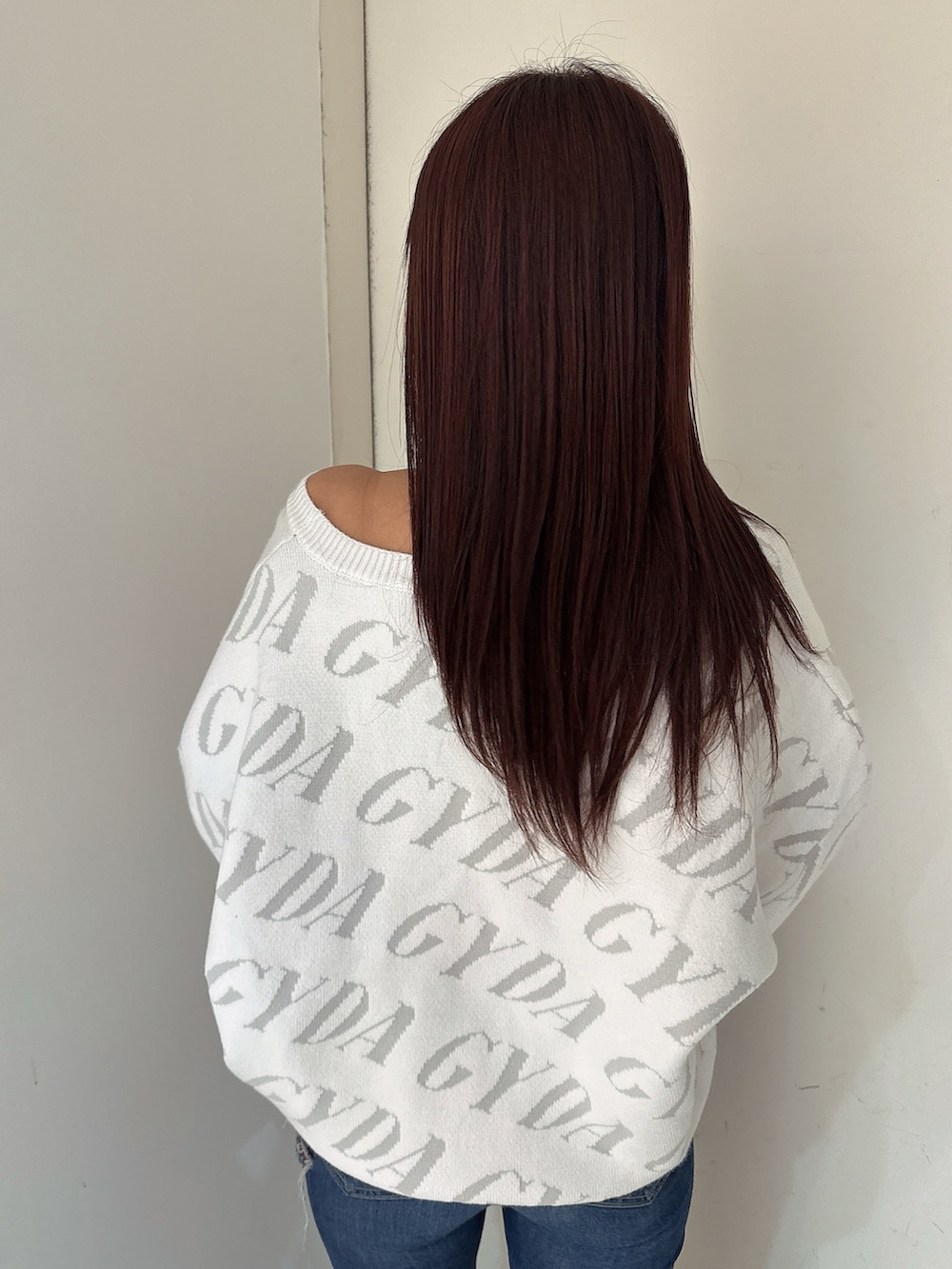 ホワイト系のニット/セーター、ブルー系のデニムパンツ、ブラック系のブーツを着用したレディースの秋コーディネートの6枚目の写真