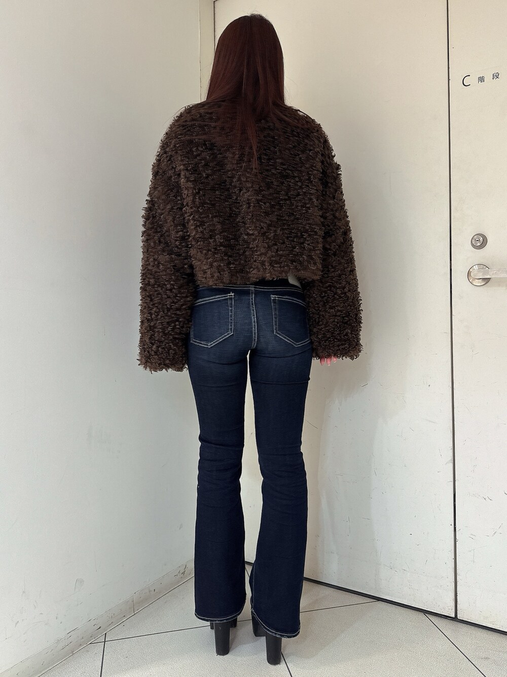ブルー系のデニムパンツ、ブラック系のブーツ、ブラウン系のブルゾンを着用したレディースの秋コーディネートの3枚目の写真