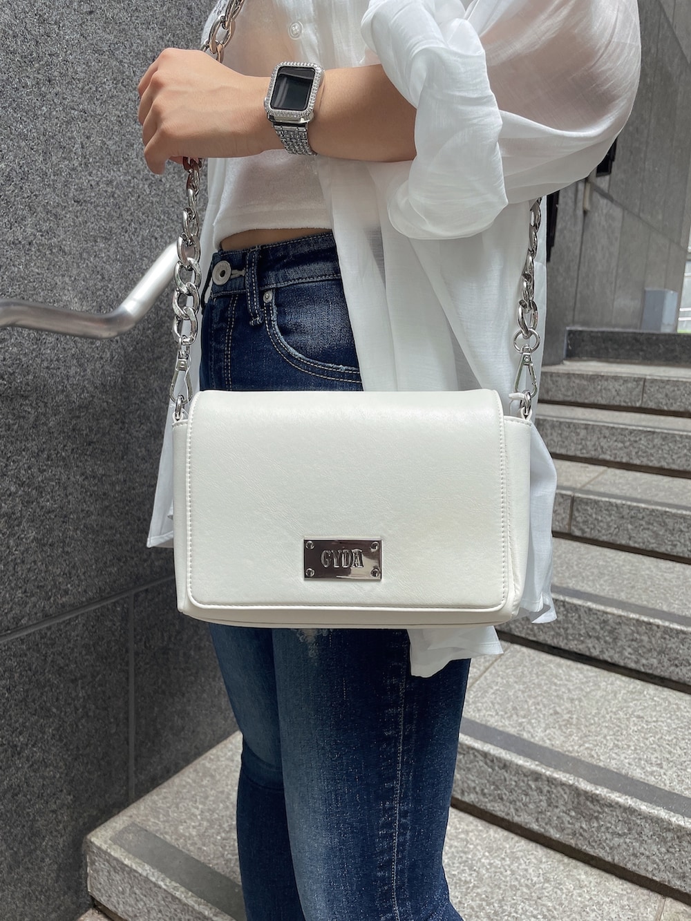 ホワイト系のシャツ/ブラウス、ホワイト系のチューブトップ、ブルー系のデニムパンツを着用したレディースの夏コーディネートの6枚目の写真