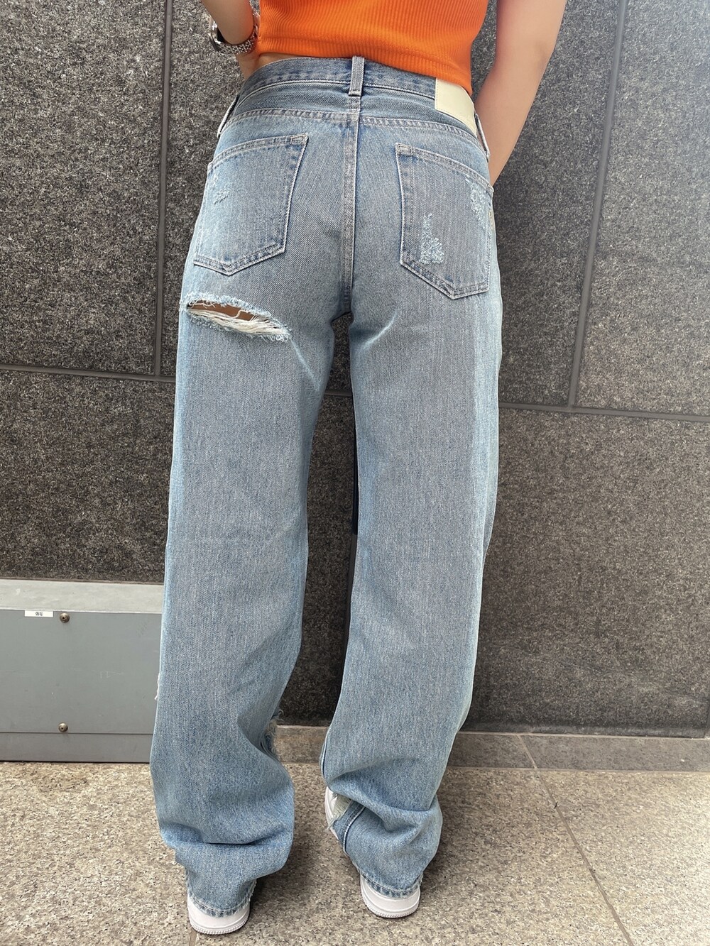 オレンジ系のTシャツ/カットソー、ブルー系のデニムパンツ、ブラック系のチューブトップを着用したレディースの夏コーディネートの7枚目の写真