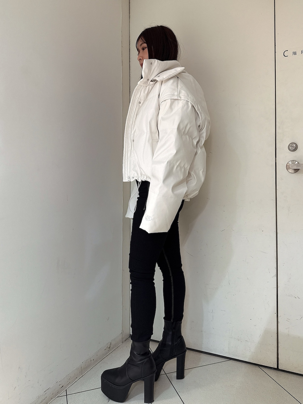 ブラック系のデニムパンツ、ブラック系のブーツ、ブラック系のニット/セーターを着用したレディースの秋コーディネートの2枚目の写真