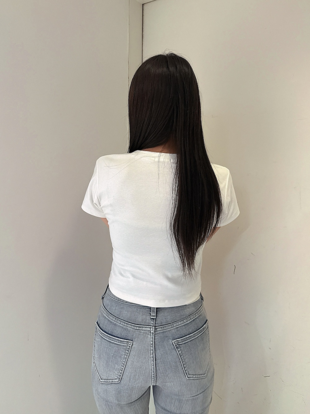 ブルー系のデニムパンツ、ホワイト系のTシャツ/カットソー、ホワイト系のサンダルを着用したレディースの春コーディネートの6枚目の写真