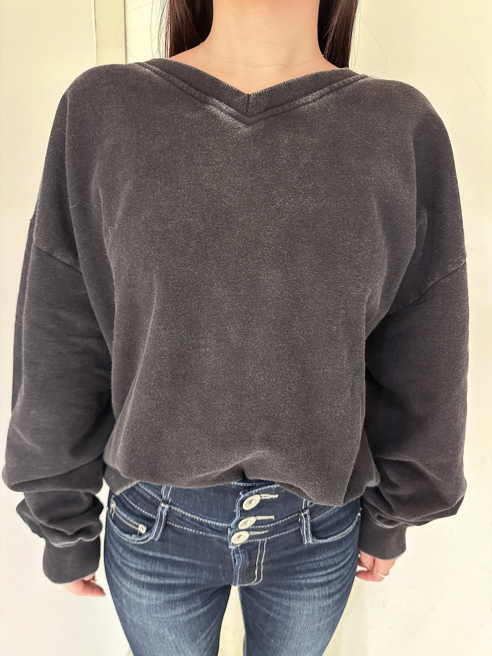 ブルー系のデニムパンツ、ブラック系のスウェット、ブラック系のブーツを着用したレディースの冬コーディネートの8枚目の写真