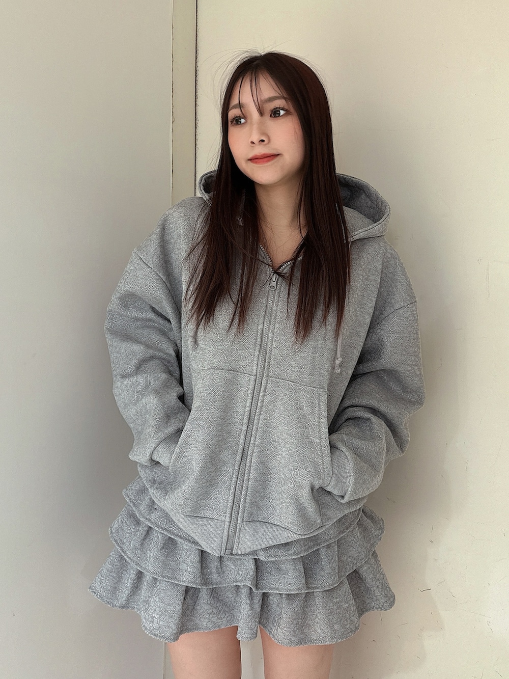 グレー系のスカート、グレー系のパーカー、ブラック系のブーツを着用したレディースの冬コーディネートの4枚目の写真