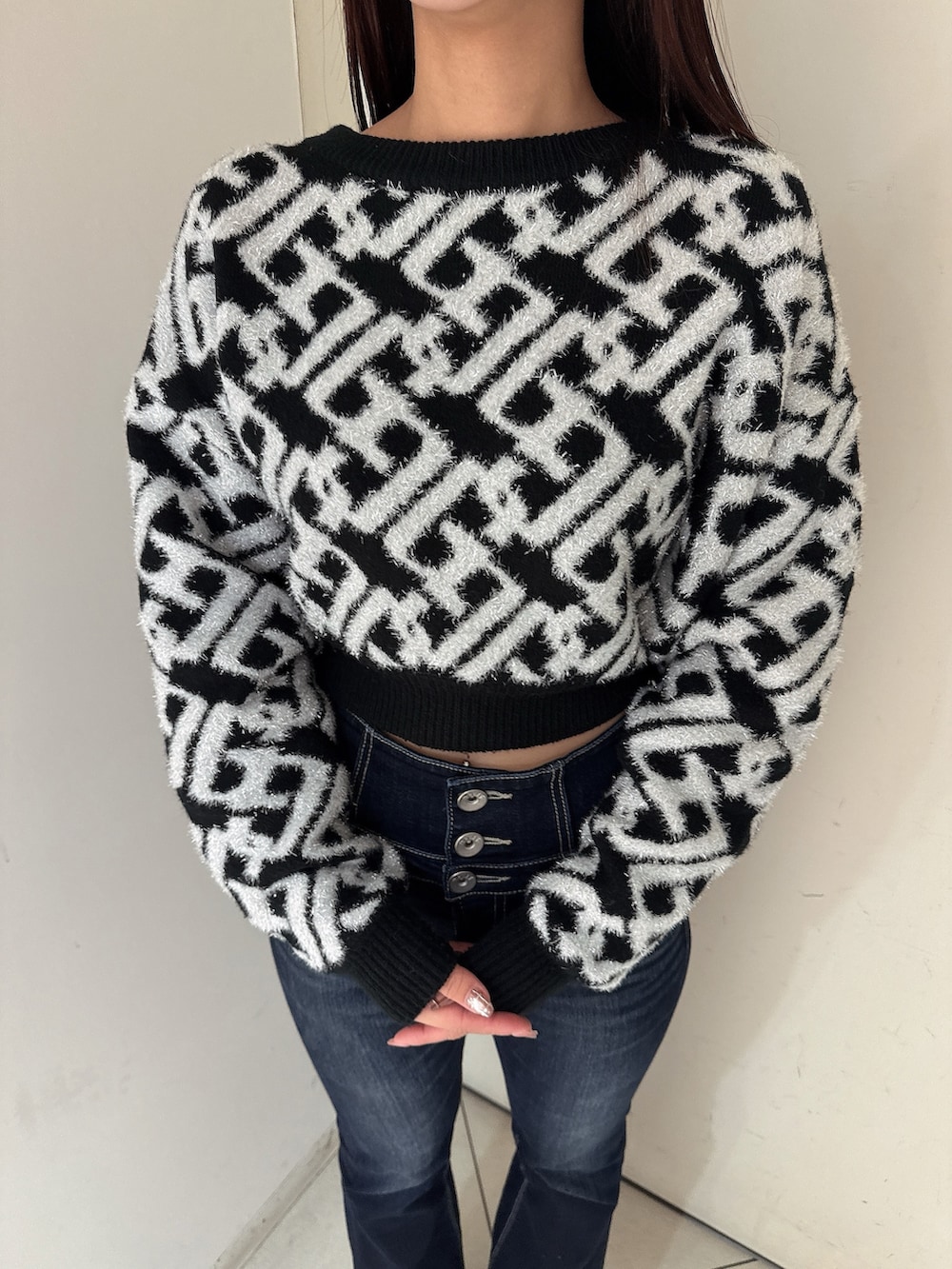 ブルー系のデニムパンツ、ブラック系のブーツ、ブラック系のニット/セーターを着用したレディースの秋コーディネートの7枚目の写真