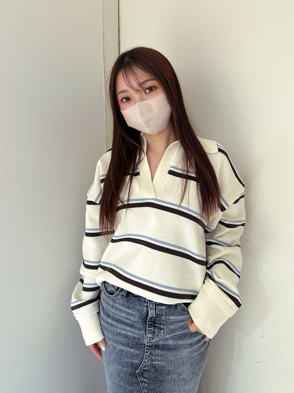 ブラック系のブーツ、ホワイト系のニット/セーター、ブルー系のデニムスカートを着用したレディースの冬コーディネートの4枚目の写真