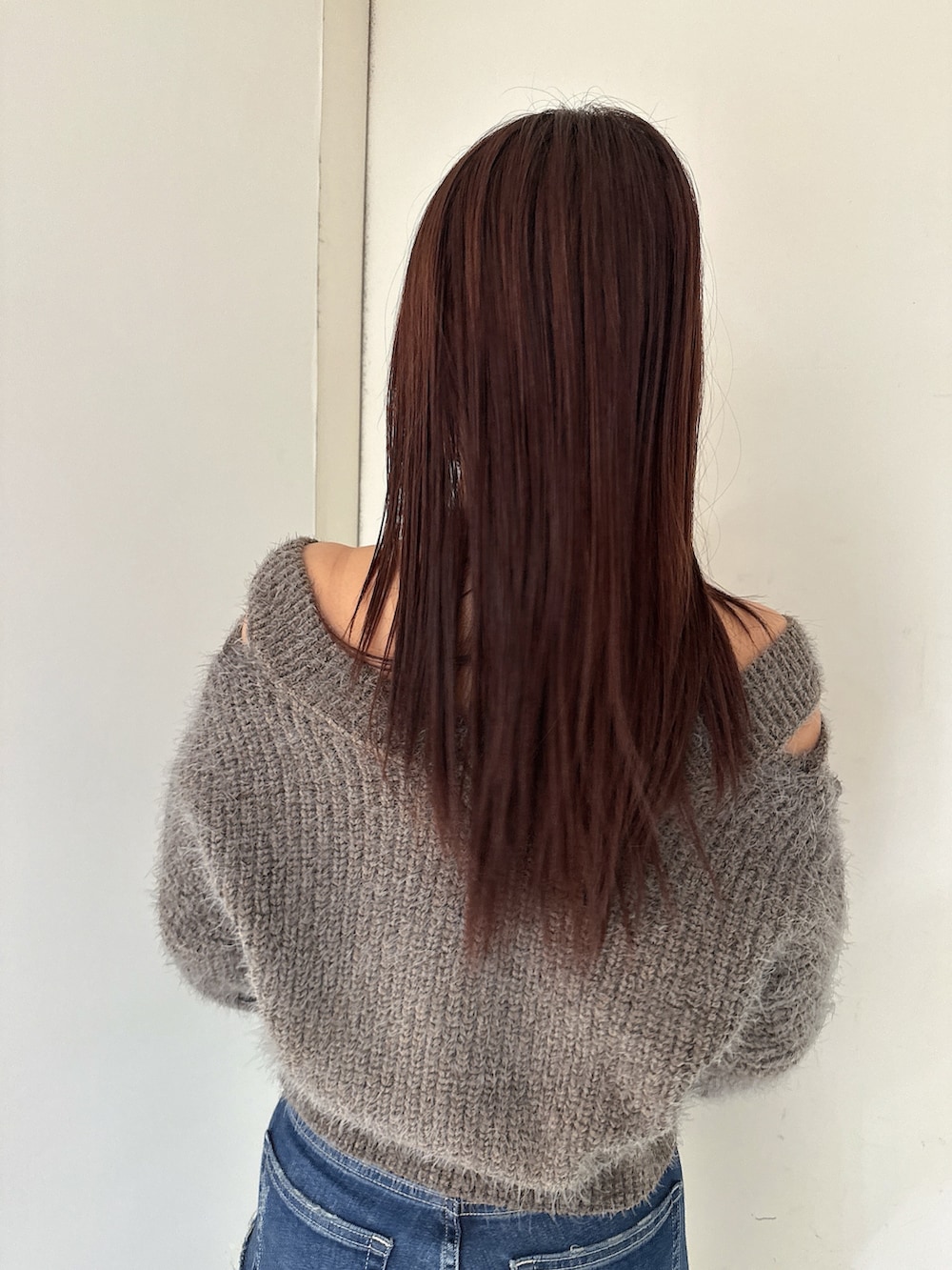 ブルー系のデニムパンツ、ブラック系のブーツ、グレー系のニット/セーターを着用したレディースの秋コーディネートの6枚目の写真