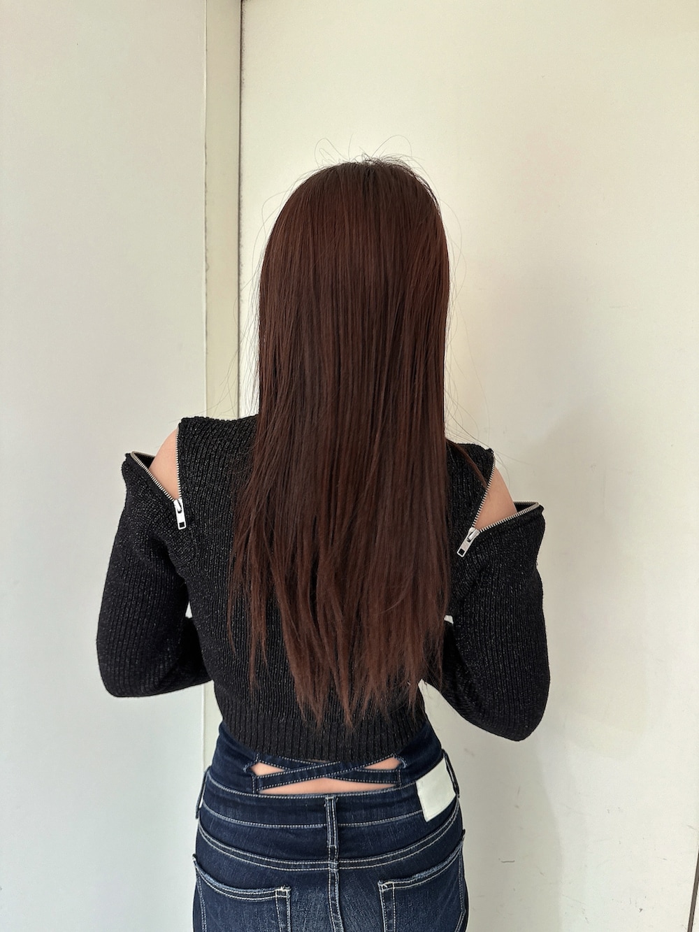 ブルー系のデニムパンツ、ブラック系のブーツ、ブラック系のニット/セーターを着用したレディースの冬コーディネートの6枚目の写真