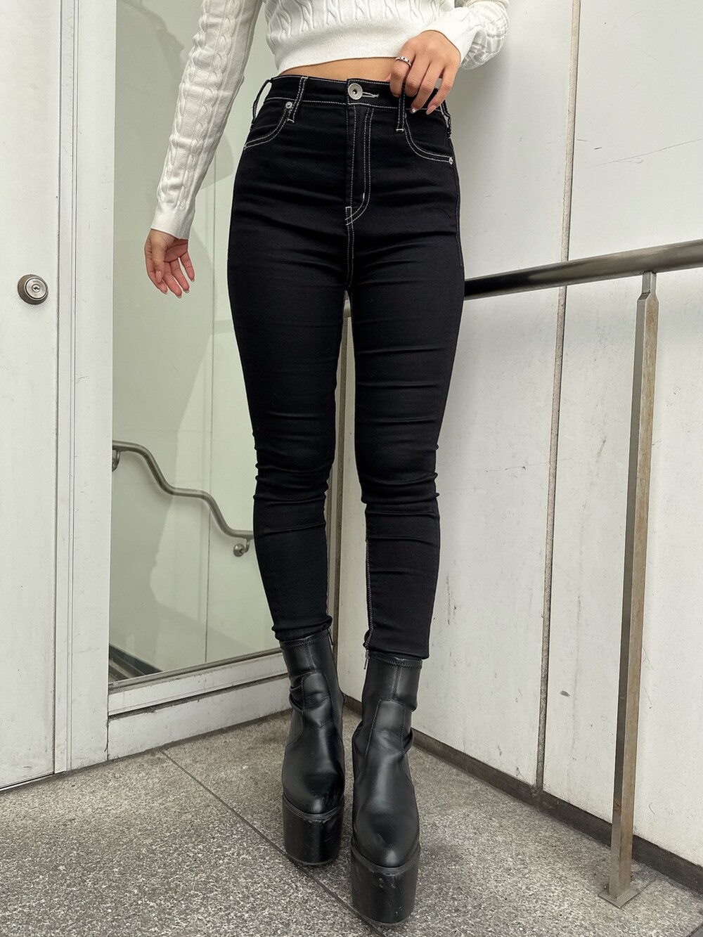 ブラック系のデニムパンツ、ブラック系のブーツ、ブラック系のその他アウターを着用したレディースの秋コーディネートの9枚目の写真